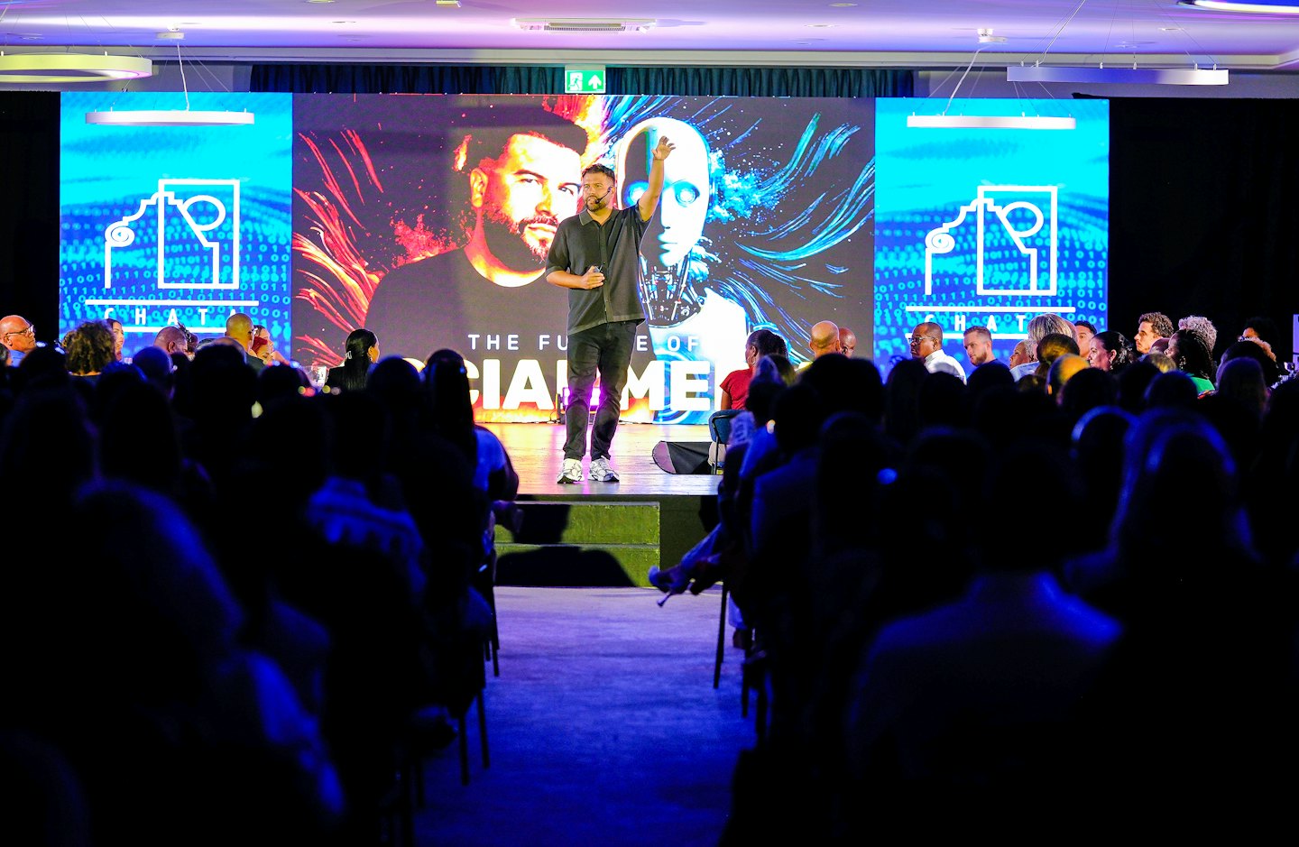 Speaker stands on stage presenting at a tech conference.